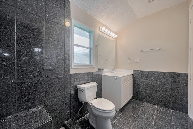 8411 Misty Vale Ln, Houston, TX 77075 - bathroom featuring tile walls, vanity, lofted ceiling, toilet, and a textured ceiling