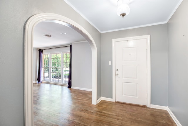 606 N Main St, Dayton, TX 77535 - foyer entrance featuring arched walkways, wood finished floors, baseboards, and crown molding