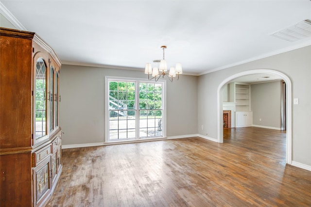 606 N Main St, Dayton, TX 77535 - unfurnished room with wood finished floors, a chandelier, arched walkways, baseboards, and crown molding