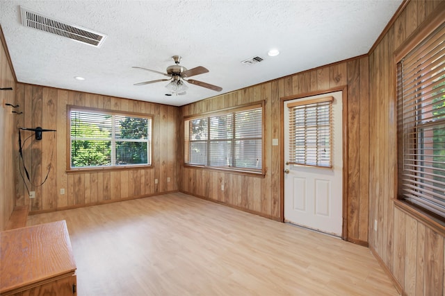 606 N Main St, Dayton, TX 77535 - entrance foyer featuring light wood-type flooring, ceiling fan, wooden walls, a textured ceiling, and baseboards