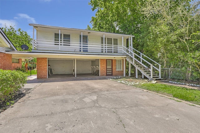 606 N Main St, Dayton, TX 77535 - view of front of home featuring an attached garage, driveway, stairway, a porch, and brick siding