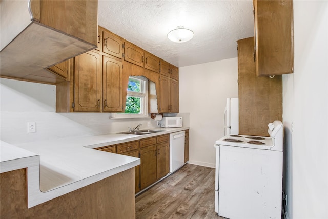 606 N Main St, Dayton, TX 77535 - kitchen featuring white appliances, a sink, light wood-style flooring, light countertops, and a textured ceiling
