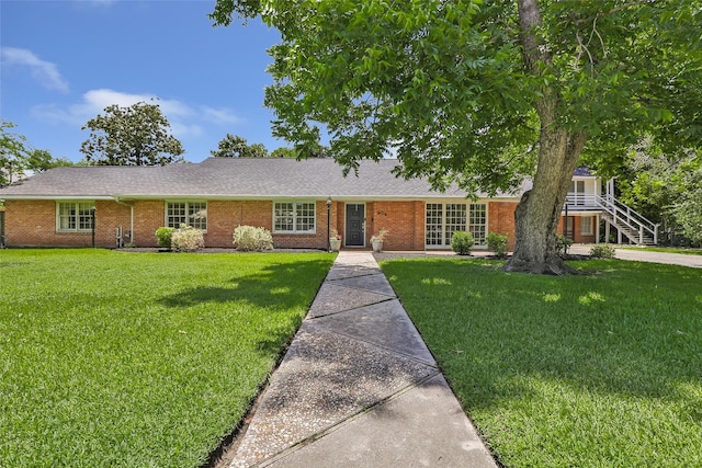 606 N Main St, Dayton, TX 77535 - ranch-style house with a front lawn, brick siding, and a shingled roof