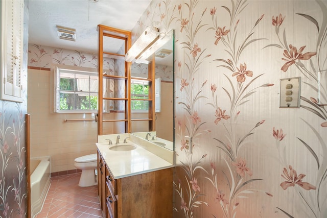 606 N Main St, Dayton, TX 77535 - bathroom with wallpapered walls, vanity, toilet, a bath, and tile patterned floors