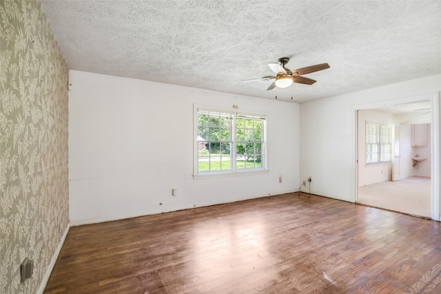 606 N Main St, Dayton, TX 77535 - empty room featuring wood finished floors, a ceiling fan, a textured ceiling, and baseboards