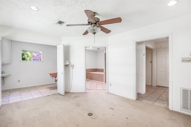 606 N Main St, Dayton, TX 77535 - carpeted empty room featuring tile patterned flooring, a ceiling fan, recessed lighting, baseboards, and a textured ceiling