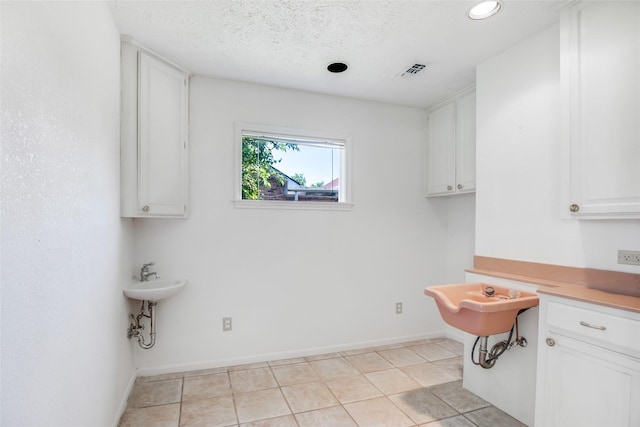 606 N Main St, Dayton, TX 77535 - washroom featuring baseboards, recessed lighting, light tile patterned flooring, and a textured ceiling