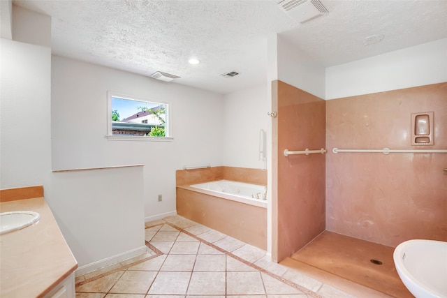606 N Main St, Dayton, TX 77535 - full bath with tile patterned flooring, vanity, a garden tub, baseboards, and a textured ceiling