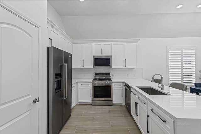 24203 Leonforte Dr, Richmond, TX 77406 - kitchen with stainless steel appliances, a sink, a peninsula, white cabinets, and recessed lighting