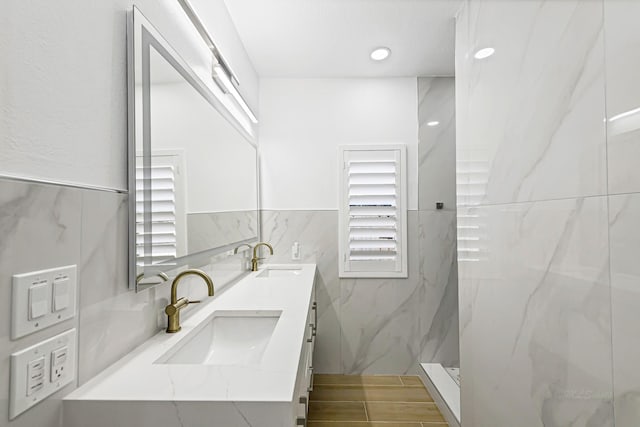 24203 Leonforte Dr, Richmond, TX 77406 - bathroom featuring double vanity, tile walls, and a marble finish shower