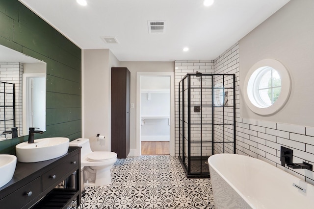 3222 Oakmont St, Houston, TX 77021 - full bath featuring a shower stall, a freestanding bath, double vanity, tile walls, and toilet