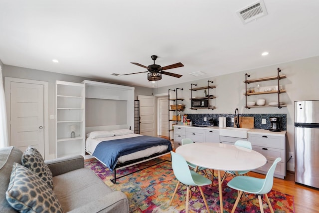 3222 Oakmont St, Houston, TX 77021 - bedroom with freestanding refrigerator, light wood-type flooring, recessed lighting, a sink, and ceiling fan