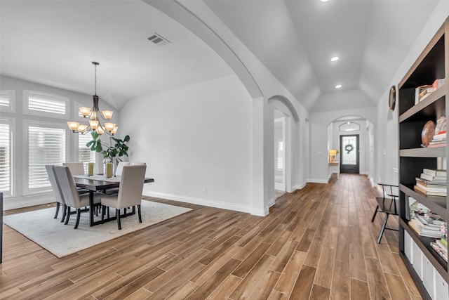 28249 Woodland Bend Way, Spring, TX 77386 - dining space with arched walkways, vaulted ceiling, wood finished floors, baseboards, and recessed lighting