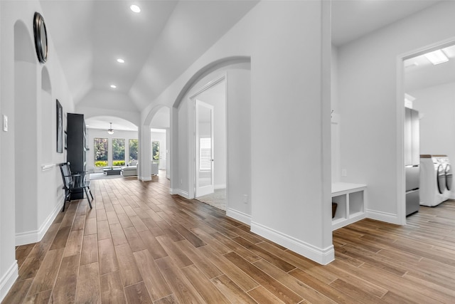 28249 Woodland Bend Way, Spring, TX 77386 - entryway with washer / dryer, wood finished floors, arched walkways, vaulted ceiling, and baseboards
