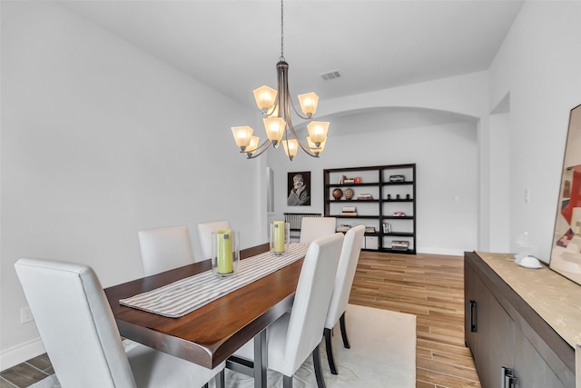 28249 Woodland Bend Way, Spring, TX 77386 - dining space featuring a chandelier, light wood finished floors, arched walkways, and baseboards