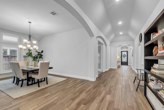 28249 Woodland Bend Way, Spring, TX 77386 - dining room with arched walkways, light wood-style floors, lofted ceiling, baseboards, and a chandelier