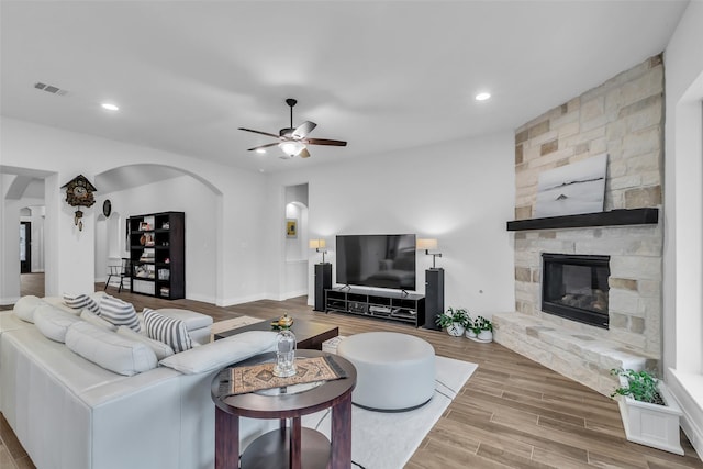 28249 Woodland Bend Way, Spring, TX 77386 - living area featuring arched walkways, ceiling fan, wood finished floors, a stone fireplace, and recessed lighting