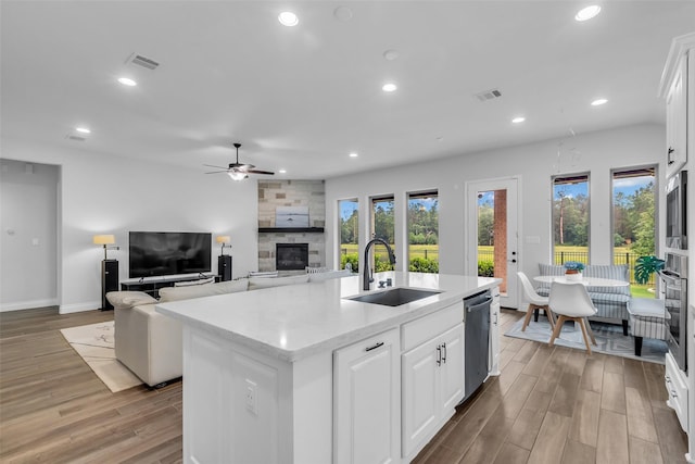 28249 Woodland Bend Way, Spring, TX 77386 - kitchen featuring a sink, a large fireplace, appliances with stainless steel finishes, light wood-style flooring, and ceiling fan