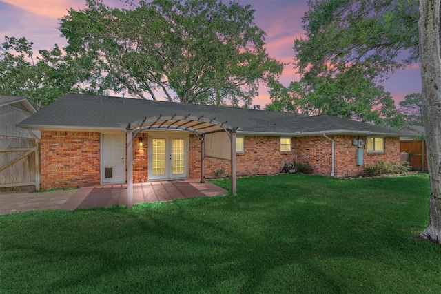 10411 Londonderry Dr, Houston, TX 77043 - back of house at dusk with french doors, a pergola, a patio area, and brick siding