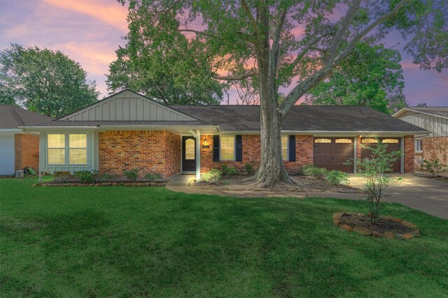 10411 Londonderry Dr, Houston, TX 77043 - single story home featuring a garage, driveway, brick siding, a front lawn, and board and batten siding