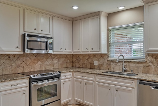 10411 Londonderry Dr, Houston, TX 77043 - kitchen featuring stainless steel appliances, a sink, light stone counters, tasteful backsplash, and recessed lighting