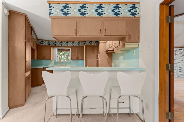 9809 Neuens Rd, Houston, TX 77080 - kitchen with a peninsula, light countertops, a kitchen bar, and a sink