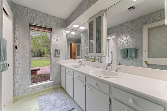 9809 Neuens Rd, Houston, TX 77080 - full bathroom featuring wallpapered walls, double vanity, tile patterned floors, and baseboards