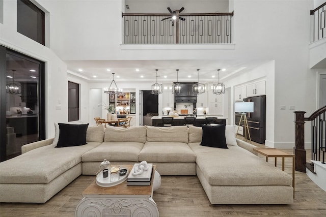 324 S Opulent Dr, Montgomery, TX 77316 - living room with a towering ceiling, stairway, a chandelier, light wood-type flooring, and recessed lighting