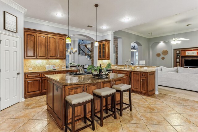 7014 Lake Haven Ct, Sugar Land, TX 77479 - kitchen with arched walkways, a chandelier, a peninsula, a kitchen bar, and decorative backsplash