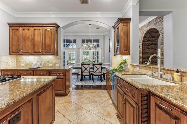 7014 Lake Haven Ct, Sugar Land, TX 77479 - kitchen featuring a sink, arched walkways, a chandelier, light stone counters, and appliances with stainless steel finishes