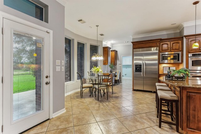 7014 Lake Haven Ct, Sugar Land, TX 77479 - kitchen with built in appliances, a kitchen breakfast bar, dark stone countertops, light tile patterned flooring, and decorative light fixtures