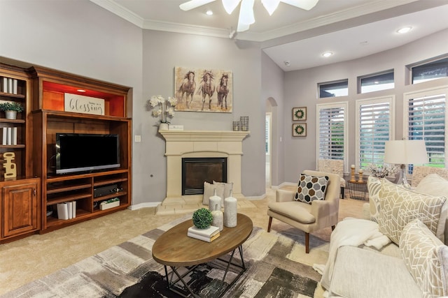 7014 Lake Haven Ct, Sugar Land, TX 77479 - living room with arched walkways, a ceiling fan, light carpet, a glass covered fireplace, and crown molding
