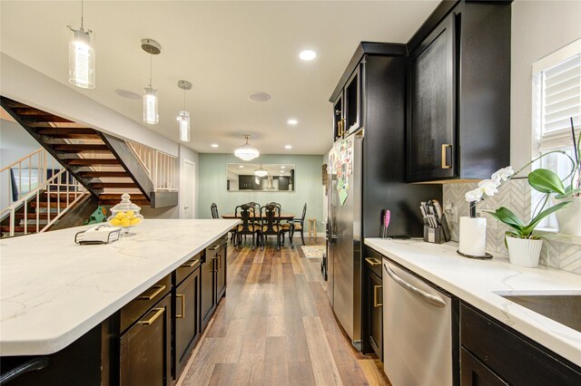 2246 Triway Ln, Houston, TX 77043 - kitchen with appliances with stainless steel finishes, recessed lighting, wood-type flooring, decorative light fixtures, and dark cabinetry