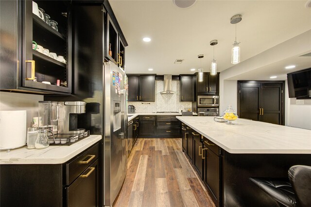 2246 Triway Ln, Houston, TX 77043 - kitchen with appliances with stainless steel finishes, wall chimney exhaust hood, light wood-style flooring, hanging light fixtures, and glass insert cabinets