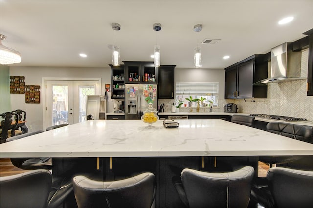 2246 Triway Ln, Houston, TX 77043 - kitchen with appliances with stainless steel finishes, wall chimney exhaust hood, a sink, decorative backsplash, and a large island