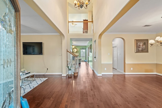 8910 Cote Ct, Houston, TX 77064 - entryway featuring a chandelier, wood finished floors, arched walkways, stairway, and baseboards