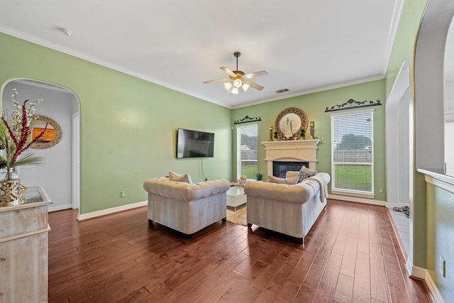 8910 Cote Ct, Houston, TX 77064 - living room featuring arched walkways, dark wood-style flooring, a ceiling fan, a glass covered fireplace, and ornamental molding