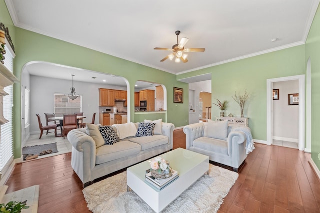 8910 Cote Ct, Houston, TX 77064 - living room featuring arched walkways, ceiling fan, hardwood / wood-style floors, healthy amount of natural light, and ornamental molding