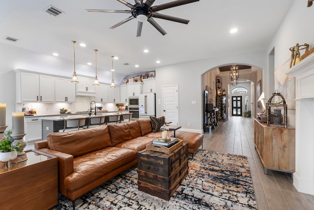 17185 Foxtrot Way, Conroe, TX 77302 - living room featuring arched walkways, a ceiling fan, light wood-style floors, baseboards, and recessed lighting