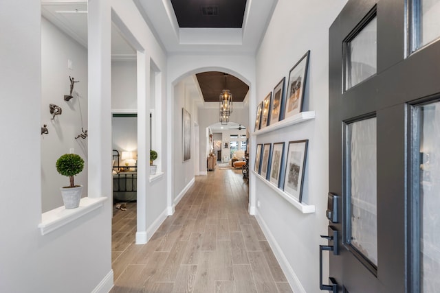 17185 Foxtrot Way, Conroe, TX 77302 - hallway featuring arched walkways, wood finish floors, a raised ceiling, and baseboards