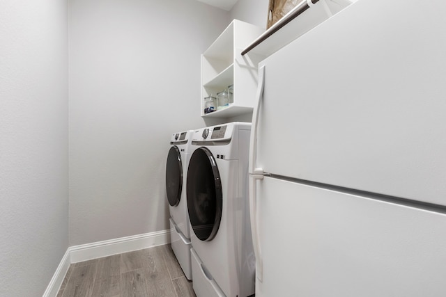 17185 Foxtrot Way, Conroe, TX 77302 - washroom with washer and clothes dryer, baseboards, and light wood finished floors