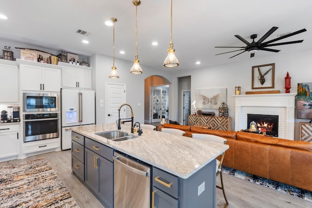 17185 Foxtrot Way, Conroe, TX 77302 - kitchen with appliances with stainless steel finishes, a sink, white cabinetry, a ceiling fan, and open floor plan