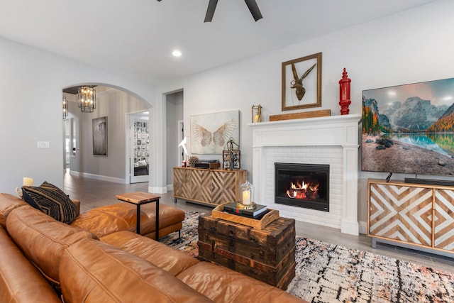 17185 Foxtrot Way, Conroe, TX 77302 - living room featuring arched walkways, ceiling fan, wood finished floors, a brick fireplace, and recessed lighting