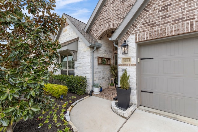 17185 Foxtrot Way, Conroe, TX 77302 - property entrance featuring stone siding, an attached garage, and a shingled roof
