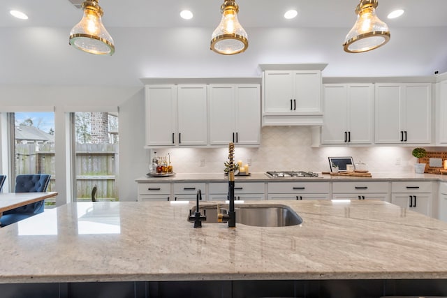 17185 Foxtrot Way, Conroe, TX 77302 - kitchen featuring backsplash, white cabinetry, decorative light fixtures, light stone countertops, and recessed lighting