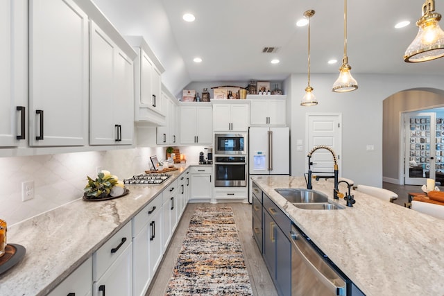 17185 Foxtrot Way, Conroe, TX 77302 - kitchen featuring a sink, appliances with stainless steel finishes, white cabinetry, arched walkways, and recessed lighting