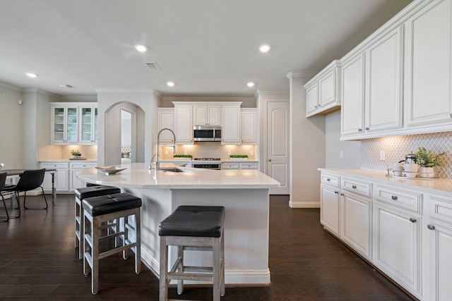 18735 Evanhale Bend Dr, Cypress, TX 77429 - kitchen with stainless steel microwave, a sink, range, arched walkways, and ornamental molding
