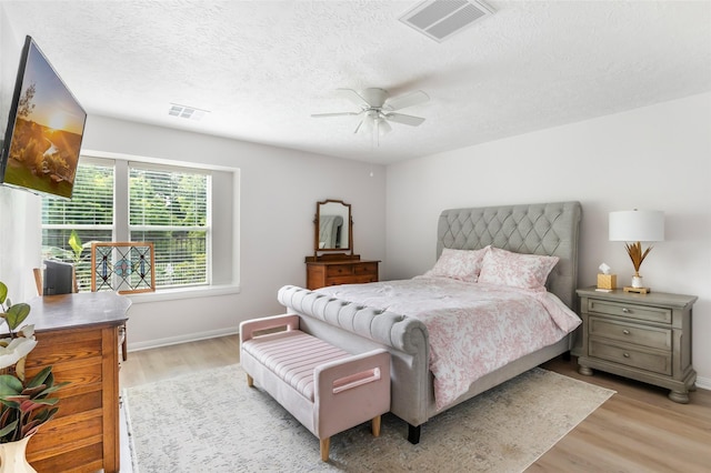 12121 Maverick Dr, Willis, TX 77378 - bedroom featuring light wood-style floors, a textured ceiling, baseboards, and a ceiling fan