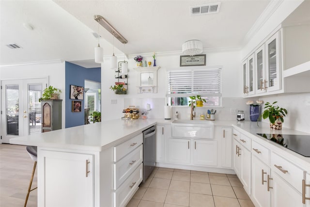 12121 Maverick Dr, Willis, TX 77378 - kitchen featuring a peninsula, dishwasher, black electric stovetop, a sink, and light countertops