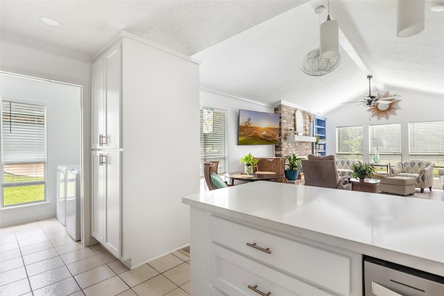 12121 Maverick Dr, Willis, TX 77378 - kitchen with light tile patterned floors, light countertops, a ceiling fan, and white cabinets